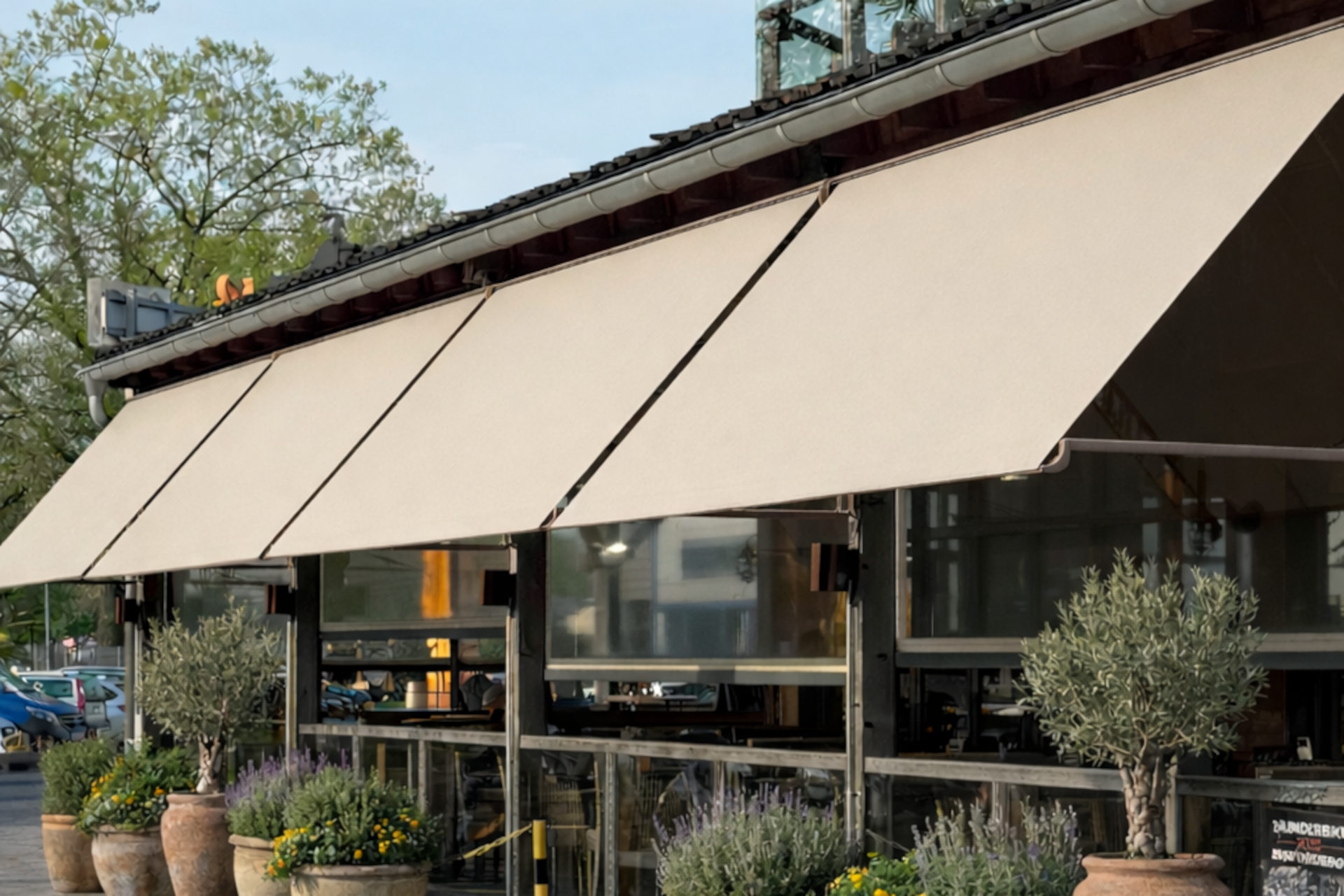 Ein Sonnensegel überdeckt eine Terasse und hüllt sie in ein angenehmes Licht