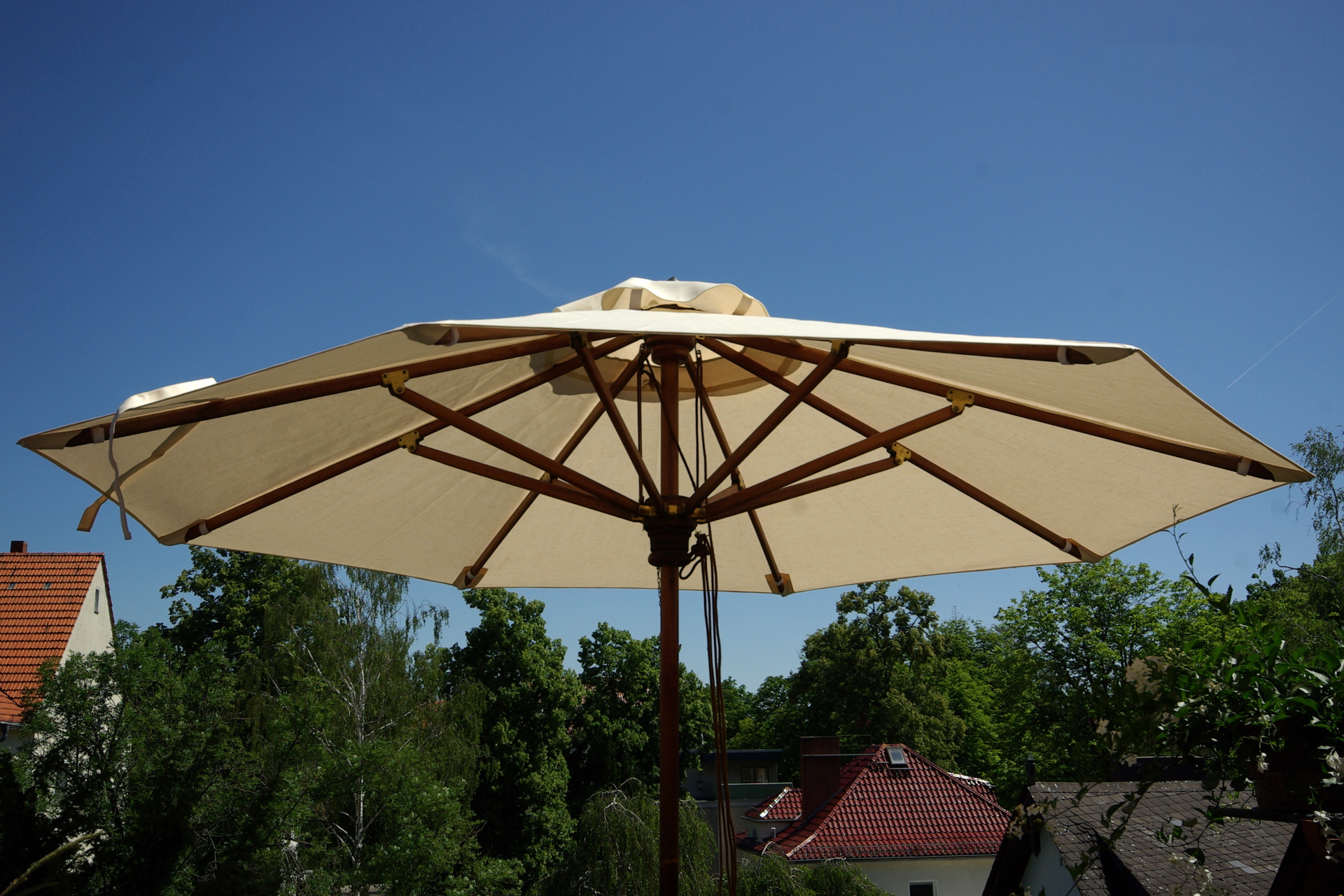 Ein Sonnensegel überdeckt eine Terasse und hüllt sie in ein angenehmes Licht